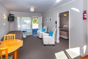 a living room with a bed and a table at Brookby Motel in Thames