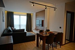 un soggiorno con divano e tavolo di Apart & Spa Zoned a Kopaonik