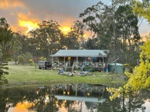 a house with a car parked next to a lake at The Sanctuary Stanthorpe in Amiens