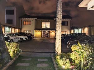 a house with cars parked in a parking lot at night at Hotel Calle Angosta in Cuenca