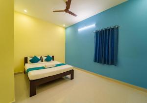 Aashikha Farm House في بونديتْشيري: غرفة نوم بسرير وجدار ازرق