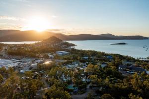 an aerial view of a resort with the sun setting over the water at NRMA Airlie Beach Holiday Park in Airlie Beach