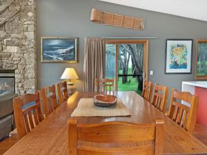 - une salle à manger avec une table et des chaises en bois dans l'établissement Les Perrieres Lodge, à Crackenback