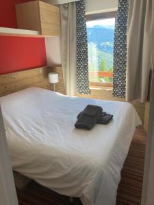 Una cama con dos toallas negras encima. en La Tania 309 Le Britania en Courchevel