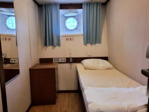 a small room with two beds and a mirror at Laivahostel S/S Bore in Turku