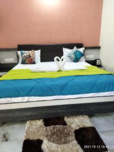 uma cama com dois cisnes brancos deitados sobre ela em Krishna Homestay Hampi em Hampi