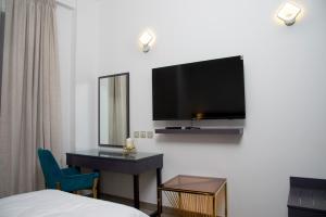 a hotel room with a bed and a television on a wall at Garden City Hotel Dubai in Dubai