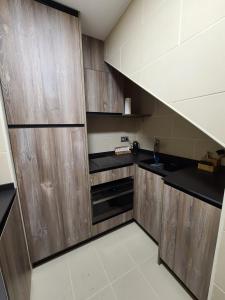 una pequeña cocina con armarios de madera y fregadero en New Dúplex a 25m del telecabina de La Massana 643, en La Massana