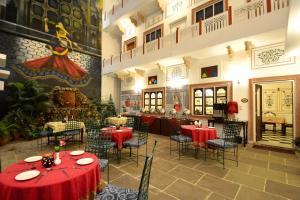 a restaurant with red tables and chairs in a room at Mahal Khandela - A Heritage Hotel and Spa in Jaipur