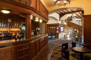 a restaurant with a bar and dinning area at The Highland Hotel in Strathpeffer