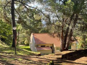 uma casa com um telhado vermelho na floresta em Bel Douro em Torre de Moncorvo