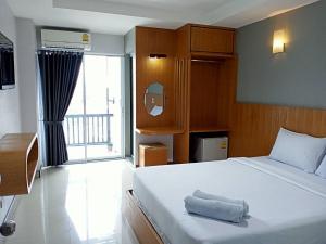 um quarto com uma grande cama branca e uma janela em @Me2 Hotel em Phitsanulok