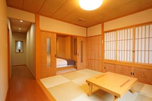 草津的住宿－索美安日式旅館，一间设有桌子和一张床的房间