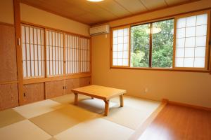 a room with a table and two windows at Soumeian in Kusatsu