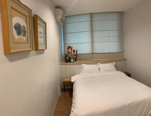 une chambre avec un lit blanc et une fenêtre dans l'établissement Baannaisoi2 Mini Hotel, à Chiang Mai 14 autres photos