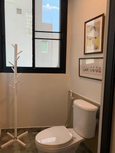 La salle de bains est pourvue de toilettes et d'une croix au sol. dans l'établissement Baannaisoi2 Mini Hotel, à Chiang Mai
