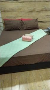 a bed with a pink object on top of it at Bangi Gateway Suite in Kampong Sungai Merab