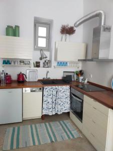 una cocina con armarios blancos y fregadero en Chora Elegant Traditional House en Amorgós
