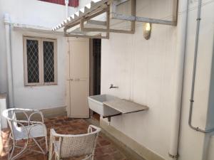 een badkamer met een wastafel en een tafel en stoelen bij Kadal Homestay in Pondicherry