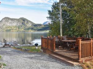 una terraza de madera con mesa y sillas junto a un lago en 2 person holiday home in Måndalen-By Traum, en Sæbø