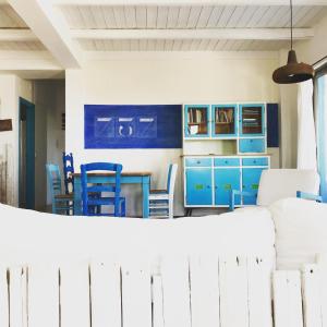 a kitchen with blue cabinets and a table and chairs at saveriako, paradise for relaxed free spirits in Agia Pelagia