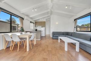 a living room with a couch and a table and chairs at Ingenia Holidays Ocean Lake in Bermagui