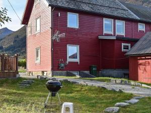 a bbq grill in front of a red house at 4 person holiday home in Måndalen-By Traum in Sæbø +17 photos