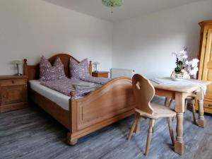 ein Schlafzimmer mit einem Holzbett mit einem Tisch und einem Stuhl in der Unterkunft Ferienhaus Josefine in Bad Endorf