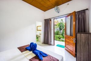 a bedroom with a bed with a blue ribbon on it at Nusa Bagus Homestay Lembongan in Nusa Lembongan +32 photos