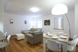 ein Wohnzimmer mit einem Tisch, Stühlen und einem Sofa in der Unterkunft Andagoia by Smiling Rentals in Hondarribia