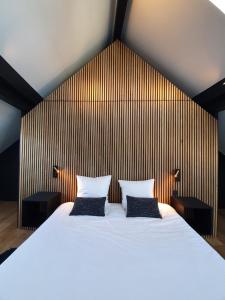 a bedroom with a large bed with two pillows at JAMES Résidence & Spa in Strasbourg