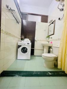 a bathroom with a washing machine and a toilet at BluO Studio Defence Colony Mkt - Kitchen, Balcony in New Delhi