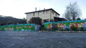 uma casa com um mural ao lado de uma cerca em Hotel Sonno D'Autore em Borghetto di Vara