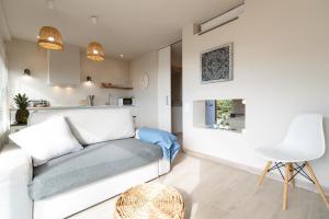 a living room with a white couch and a table at Ocean view apartment renovated in Gavà