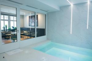 a room with a tub with a table and chairs at JAMES Résidence & Spa in Strasbourg