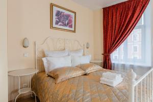 サンクトペテルブルクにあるOctaviana Hotelのベッドルーム1室(ベッド1台付)、赤いカーテン付きの窓が備わります。