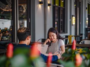 a young girl talking on a cell phone at ST Signature Tanjong Pagar in Singapore