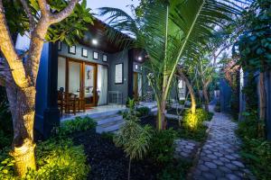 a house with palm trees in front of it at Nusa Bagus Homestay Lembongan in Nusa Lembongan