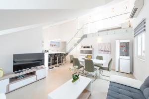 a living room with a couch and a table and chairs at TopDeck Exclusive Apartment in Dubrovnik