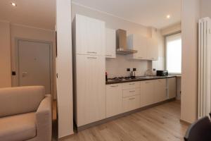 a kitchen with white cabinets and a counter top at Rossini15 - garage privato in Alba