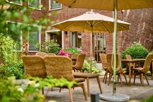 a group of chairs and tables with an umbrella at HOTEL KOCKS am Mühlenberg in Mülheim an der Ruhr