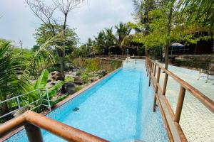 a view of a swimming pool at a resort at Hotel dan Gazebo Pinggir Kali Prigen Mitra RedDoorz in Pasuruan