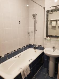 a bathroom with a tub and a sink at Grand Hall Hotel in Yekaterinburg