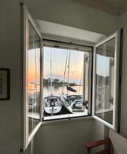 a window with a view of a boat in a harbor at Dolce Vivere by Konnect, Gaios Paxos in Gaios