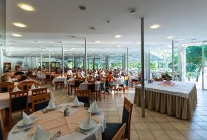 a restaurant with tables and people sitting at tables at Tourist Settlement Brzet in Omiš