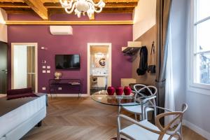 a living room with purple walls and a glass table at Kairos by Florence Art Apartments in Florence
