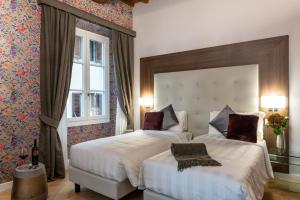 Cette chambre comprend 2 lits et une fenêtre. dans l'établissement Kairos by Florence Art Apartments, à Florence