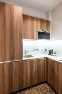 a kitchen with wooden cabinets and a sink at Kairos by Florence Art Apartments in Florence