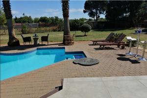 a swimming pool with a picnic table and a bench at Shai's Nest in Centurion