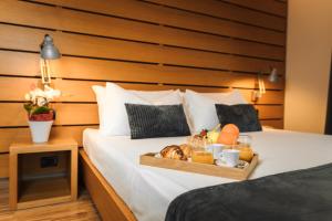 a tray of fruit and juice on a bed at Lake Front Hotel Mirage in Riva del Garda